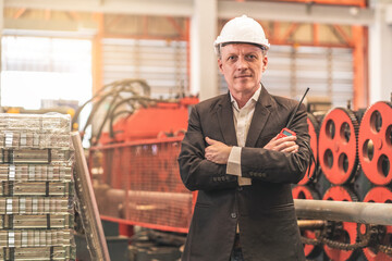 White factory owner, senior man wearing a suit, wearing an engineer's hat, arms crossed, holding a radio, succeeds in believing in the steel mill.