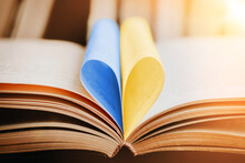 Close Up Opened Book With Blue And Yellow Heart Shaped Pages. Education In Ukraine Concept
