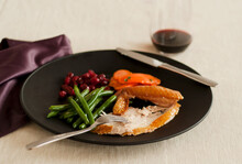 Single Serving Of Turkey On A Plate With Green Beans, Cranberries, Carrots And Red Wine