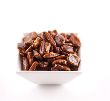 Bowl Of Candied Pecans On A White Background
