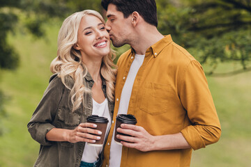 Poster - Portrait of amorous beautiful handsome cheerful couple spending weekend drinking latte kissing flirting outdoors