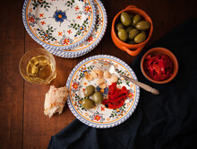 Plate With A Single Serving Of Tapas; Green Olives, Roasted Red Peppers And Almonds; Bread And White Wine