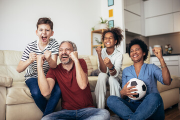 Excited family football fans watching sport tv game celebrating goal together