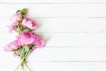 Wall Mural - abstract border of beautiful pink and white peony flowers on white wooden background with copy space