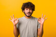 © Face Stock - Everything is fine. Satisfied bearded curly Indian man showing ok gesture with fingers, approving work, satisfied with quality. Indoor studio shot isolated on yellow background