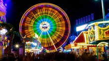 Spinning Ferris Wheel In Motion On Funfair. An Abstract Blurred Background Object Image Of Ferris Wheel At Night