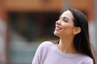 © PheelingsMedia - Happy woman looking at side in the street