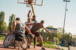  A physically challenged person play street basketball with his friends.			