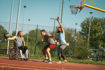  A physically challenged person play street basketball with his friends.				