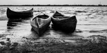Several Canoes Set On The Shore Of The Lake In The Early Evening Black And White