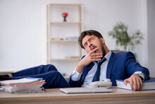 Young Male Employee Extremely Tired In The Office