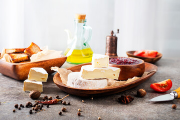 Canvas Print - Camembert cheese with figs, raspberry jam. Round brie or camambert cheese on cutting board