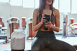 Young active woman taking a break in the gym and drinking protein shake.