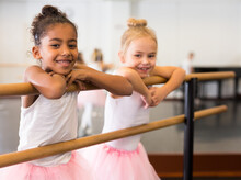 Two Little Girls Practicing Ballet Elements And Positions In Dance Studio