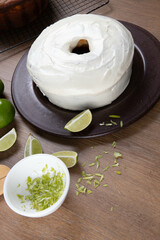 Wall Mural - Moist lemon fruit cake on plate with lemon slices on wooden table. Delicious breakfast, traditional tea time. Lemon cake recipe. Top view.