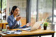 © David - Good looking young Asian woman in pants jacket and tie working with documents in the office