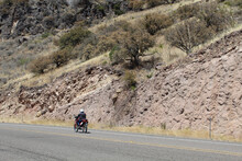 Man On A Motorcycle Riding Uphill At The Davis Mountains Scenic Loop In West Texas