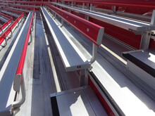 Side View Of Aluminum Bleacher Seats With Back Rest At A Stadium Or Concert Venue.