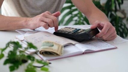 Wall Mural - a man counts a bill on a calculator on the table. payment of utility services. saving energy and mon