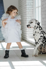 Fashion children. Little girl with a dog posing in fashionable clothes. High quality photo