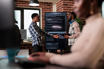 African american software developer pointing out cloud database processing algorithm error. Cybernetics engineers talking about deciphering stolen corrupted and ecrypted important company files.