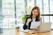 © PaeGAG - Portrait of Asian young female working on laptop and financial report at office.