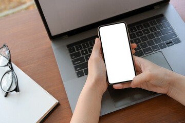 Female using smartphone over her office desk.