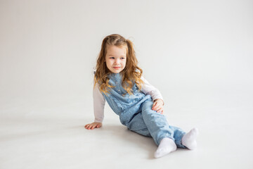 beautiful cute baby girl lies on her stomach and looks into the camera with slightly wavy hair. pretty Baby. happy childhood.