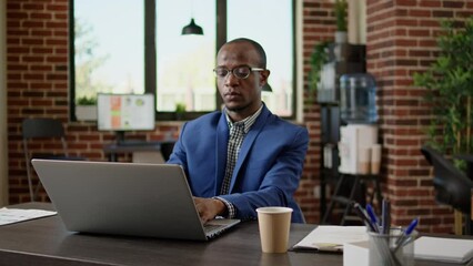 Poster - Portrait of businessman using laptop to browse internet in startup office, doing project research. Executive manager sending paperwork email, wokring on website browser application.