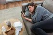 © Syda Productions - mental health, psychological help and depression concept - stressed woman with smartphone lying on sofa at home