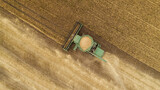 Fototapeta Na ścianę - Aerial view combine harvester harvesting on the field