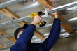 Man fasten metal profile frame to the ceiling for plasterboard installation