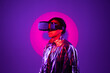 © VISTA by Westend61 - Spotlight falling on woman wearing virtual reality simulator against purple background