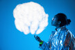 © VISTA by Westend61 - Woman looking at cloud computing against blue background