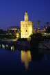 Seville (Spain). Night view of the Torre del Oro next to the Guadalquivir river in the city of Seville