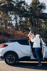 Mother with her little son by the car