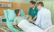 © supAVADEE BUTRADEE - Doctor with nurse visits an elderly woman lying in bed together to discuss her condition and recommend treatment in the hospital