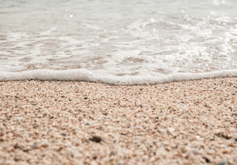 Wall Mural - Beach sand sea water summer background. Sand beach desert texture.
White foam wave sandy seashore