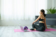 © Jirapong - stress relief, muscle relaxation, breathing exercises, exercise, meditation, portrait of Young Asian woman relaxing her body from office work by practicing yoga by watching online tutorials.