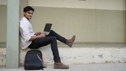 A university student is learning lessons online while sitting at the university campus