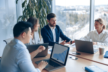Wall Mural - Creative business team working on project in modern office with panoramic view. The concept of unity and teamwork.