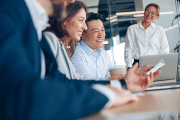 Wall Mural - Close up of smiling confident businesswoman wearing eyeglasses on business meeting with colleagues in office 