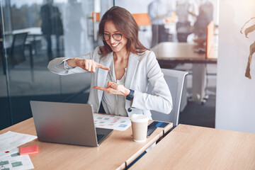 Wall Mural - Confident deaf businesswoman communicating in video call at her workplace at modern office. 