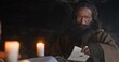 © procinemastock - Wiseman reading scroll near candles