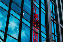 High-rise Building With A Reflection Of A Red Crane In The Windows