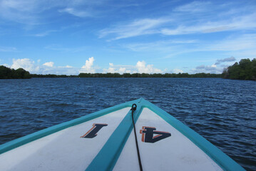 Canvas Print - POV of calm clear lake from a floating boat