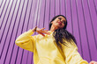 © Dani D.G - Bottom view of urban dancer in yellow dress on purple background. Low angle shot of a young woman dancing outdoors, urban style and youth fashion concept.