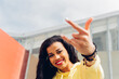 © Dani D.G - Woman making the heavy metal symbol with her hand. Young teenage woman making the horns gesture with her hand.