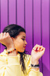 © Dani D.G - Portrait of the face of a young trap dancer, with yellow clothes and a purple background. African girl dancing relaxed current music outdoors.
