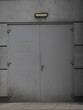 Vertical shot of a grey and lifeless metal entrance door of a building